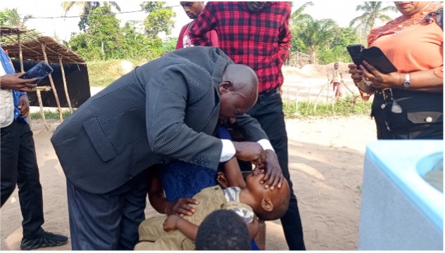 Local Leader Administering Polio Vaccine in DRC A community leader administers oral polio drops to a child during a local immunization campaign in the Democratic Republic of Congo (DRC), underscoring community involvement in vaccination efforts.