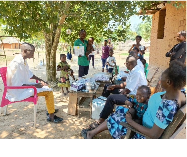 Polio Vaccination Awareness Session A community health worker explains polio vaccination efforts to local families under a tree, while others observe and listen attentively.