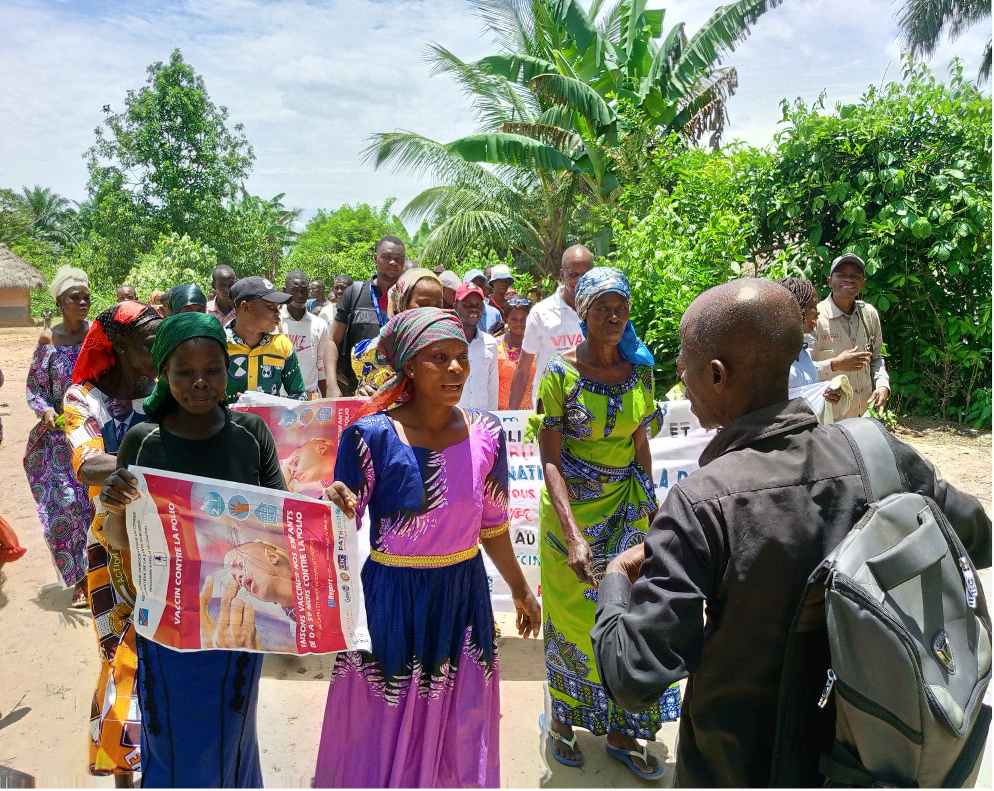Community Awareness Walk Against Polio in DRC Women in a local community in DRC hold banners and posters during an awareness march against polio, raising attention for vaccination efforts.