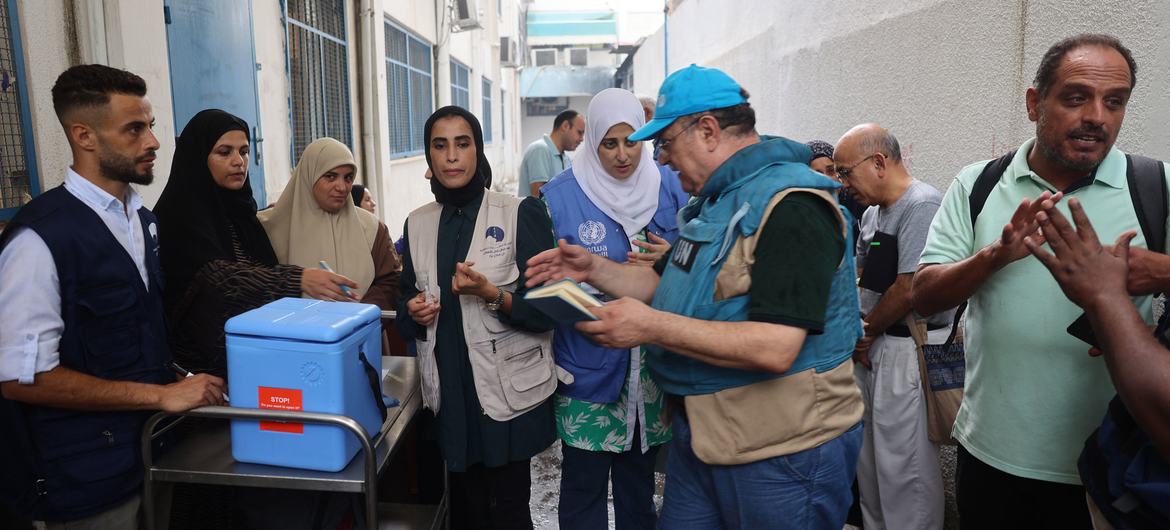 Polio Vaccination Effort in Gaza UNICEF and WHO staff coordinate a polio vaccination campaign in Gaza, discussing logistics with local healthcare workers.