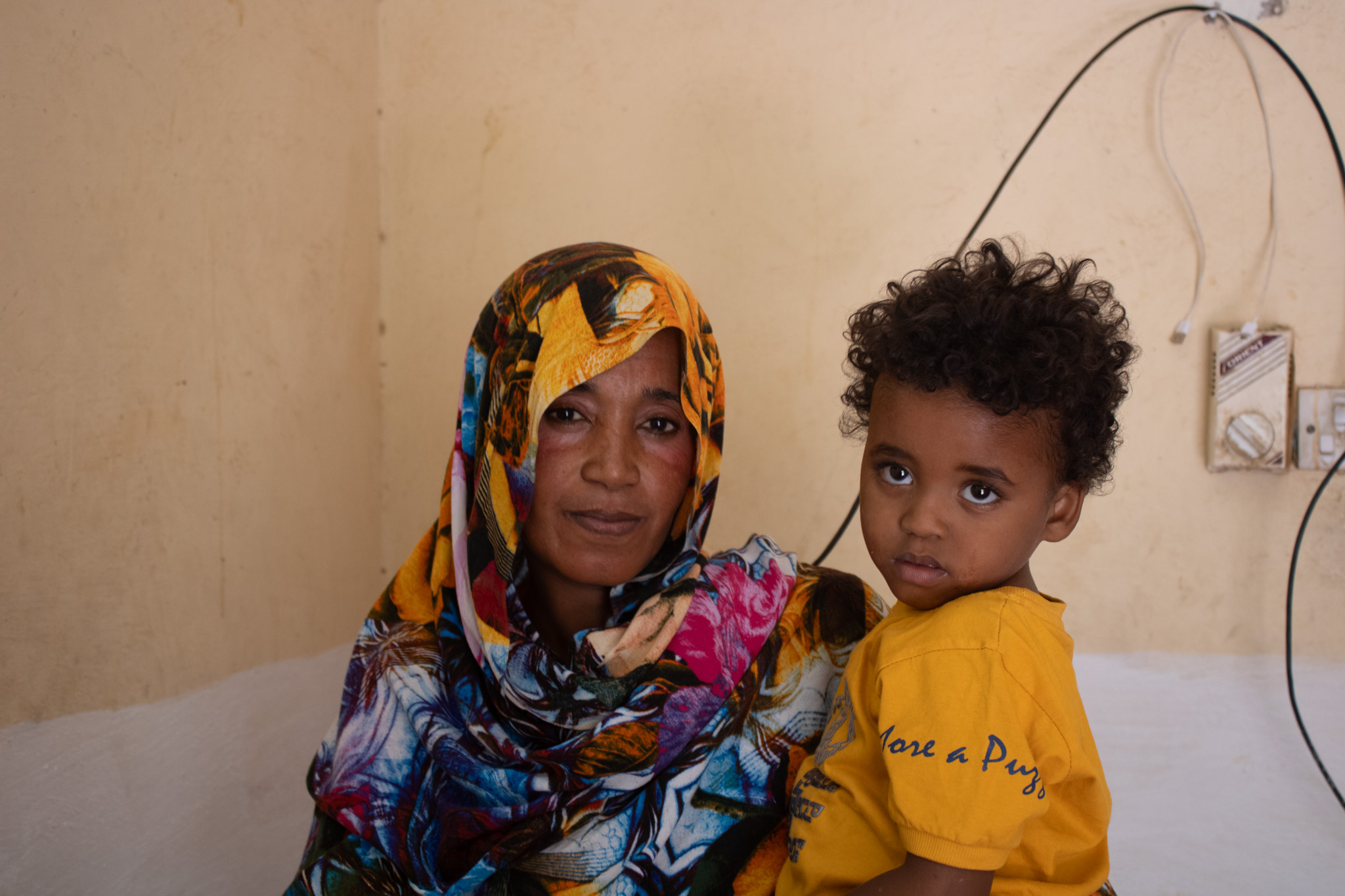 Mother and Child A mother sits with her young child, awaiting a consultation or vaccination.