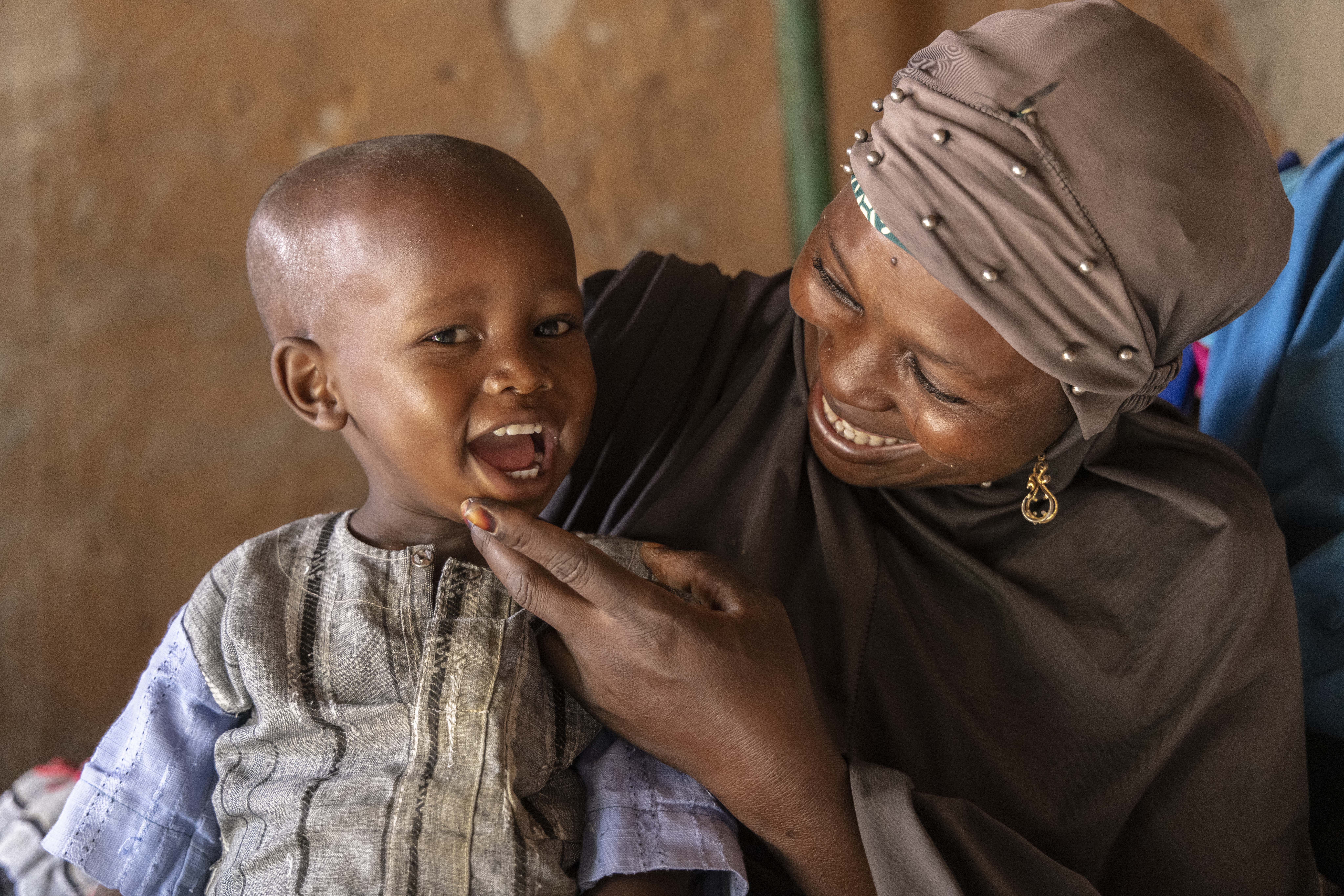 Mother and child smiling at each other warmly, sharing a joyful moment.
