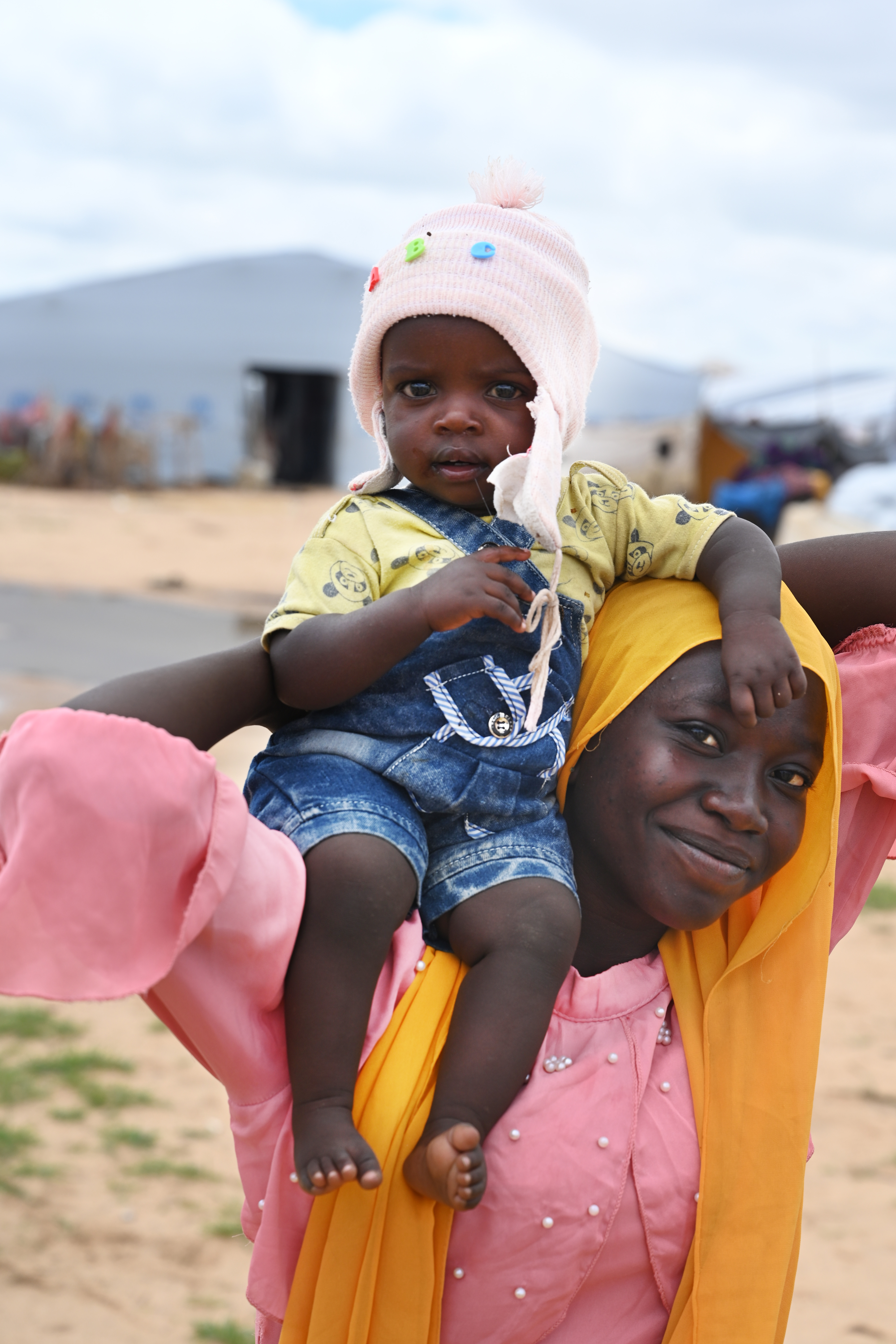 Mom holding baby on her shoulder and smiling