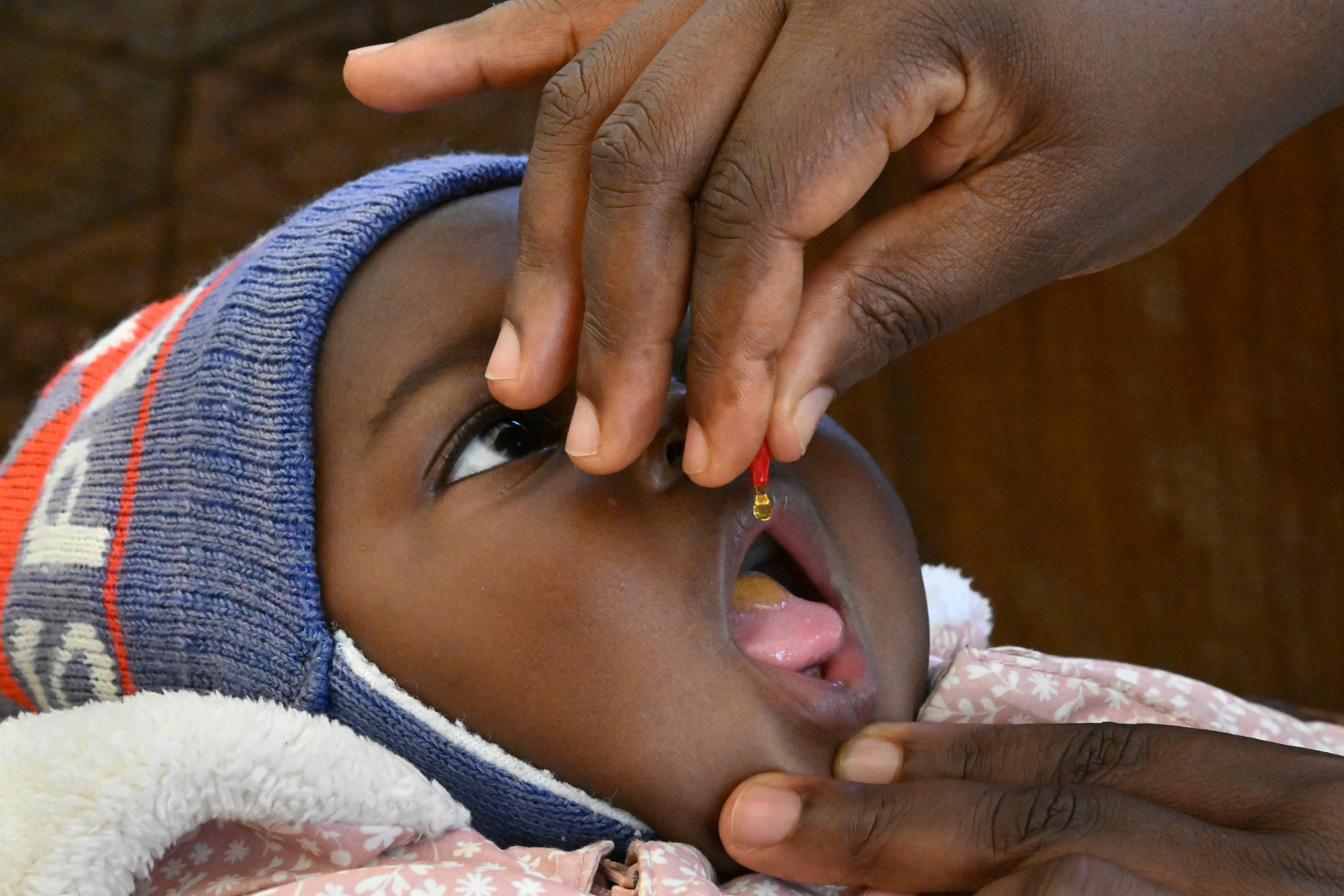 Baby taking the vaccine drops