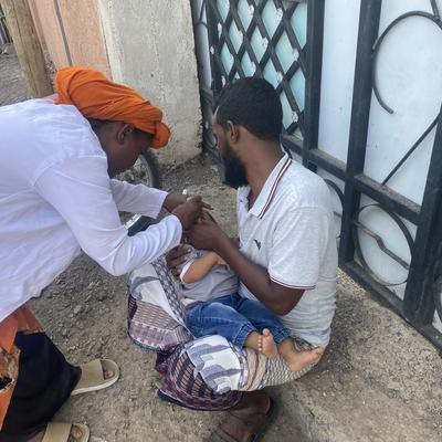 Esmail Yenus, a father in Ethiopia’s Afar region, proudly holds his two children, showcasing his active involvement in their immunization journey