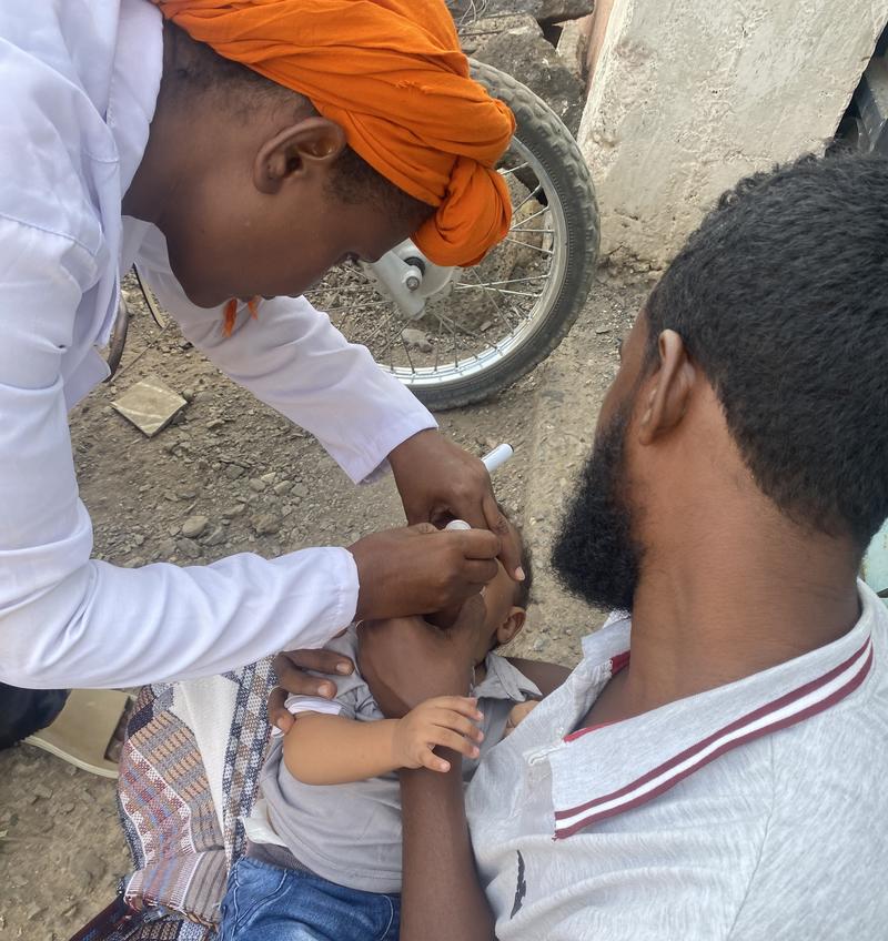Esmail Yenus, a father in Ethiopia’s Afar region, proudly holds his two children, showcasing his active involvement in their immunization journey.