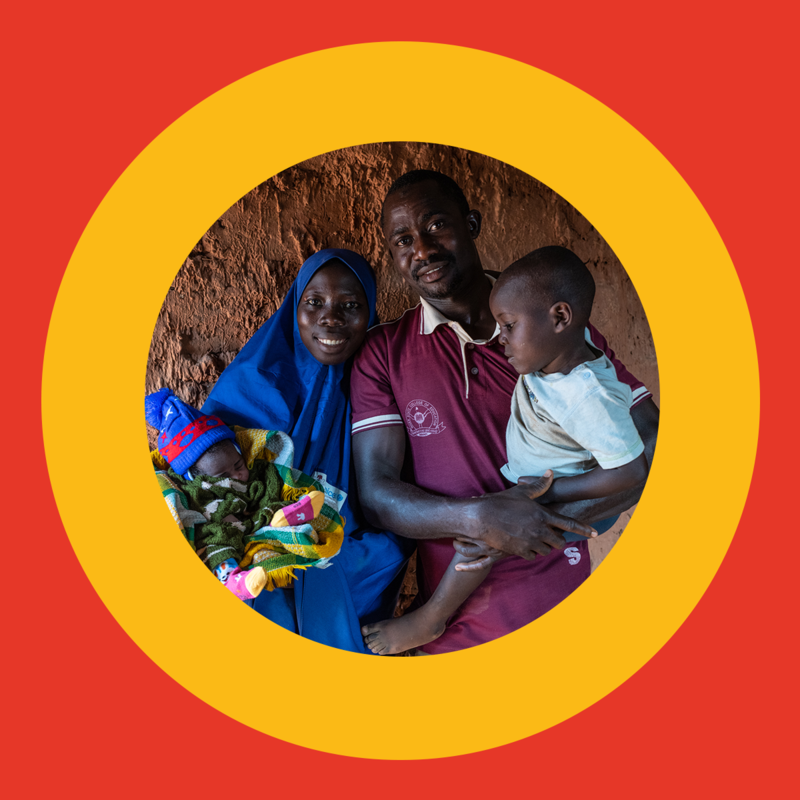 A father and a mother holding two kids in the middle of a yellow circle