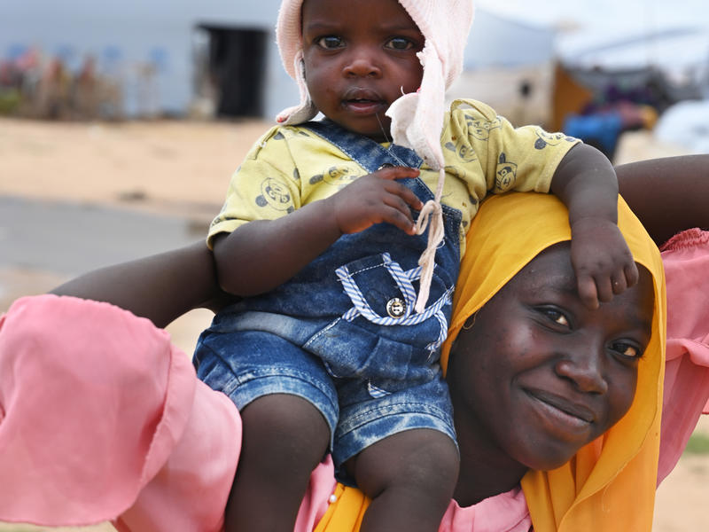 Mom holding baby on her shoulder and smiling
