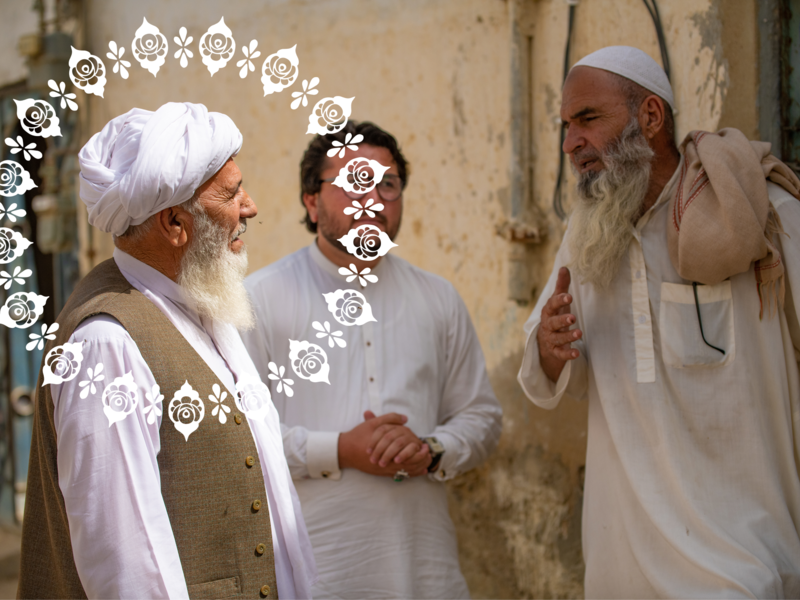 Three older men talking in the street