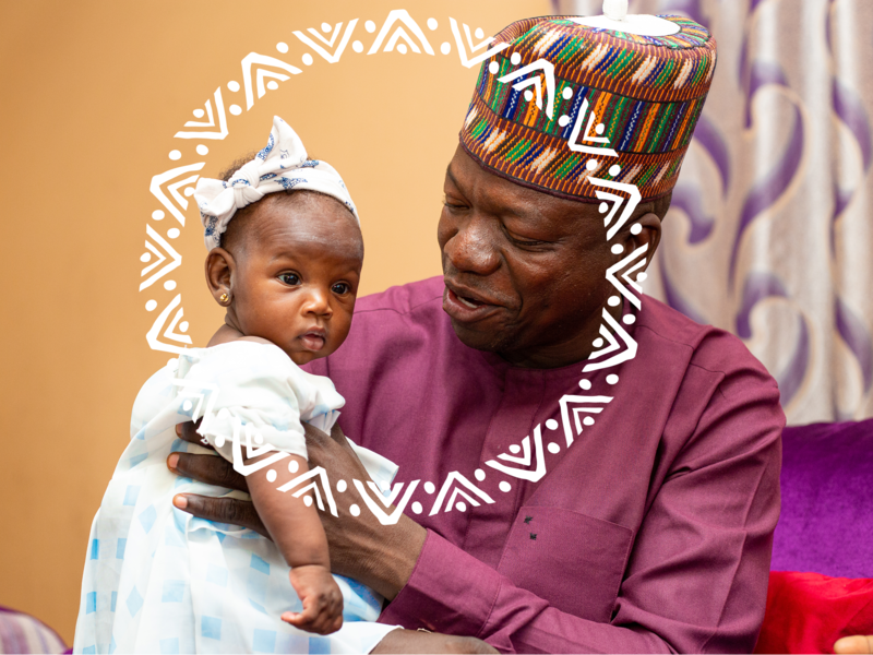 A grandparent holding his grandbaby