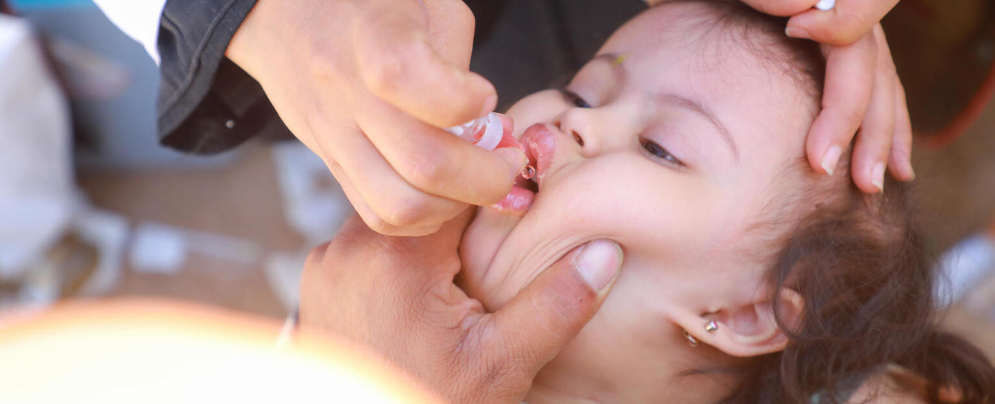 Health workers give children the oral polio vaccine during the UNICEF-supported immunization campaign in the Community College IDP camp in Marib City, Yemen, in November 2021.