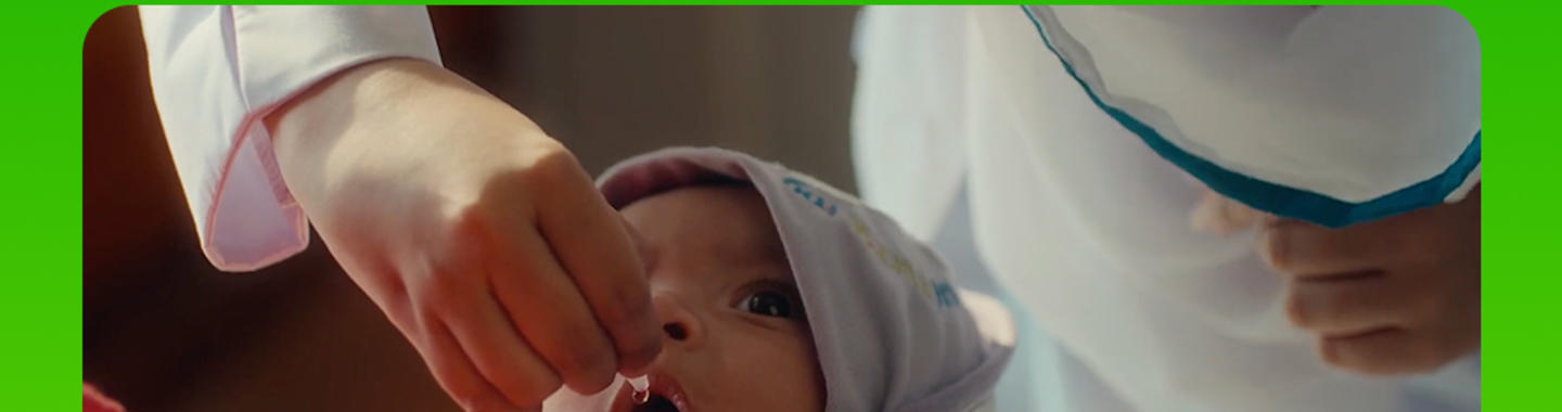 A healthcare worker gives two polio drops to a baby during Pakistan's National Immunization Days. Text reads: “Two drops today, no tears tomorrow. Let your children have a polio-free future.”