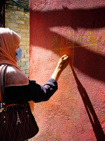 hok Hassu, Dist Rawalpindi,Pakistan, Polio staff Nighat Bibi age 25 is marking on the wall in national immunization day (NID)